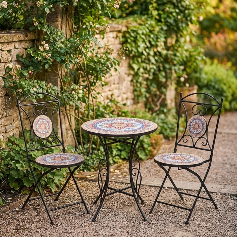 Conjunto de jardín compuesto por mesa redonda y dos sillas plegables de estructura metálica negra con asiento y tablero de mosaico decorativo, ideal para terraza o patio exterior.