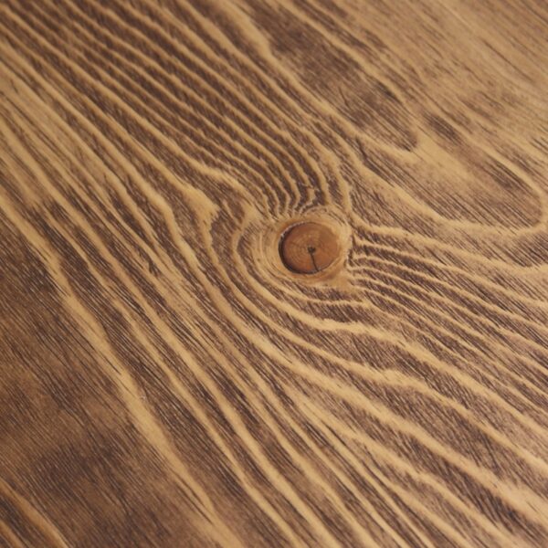 Mesa de comedor redonda de Artisa con base de diseño metálico negro y tapa en madera natural, ideal para crear un ambiente moderno y acogedor en tu hogar