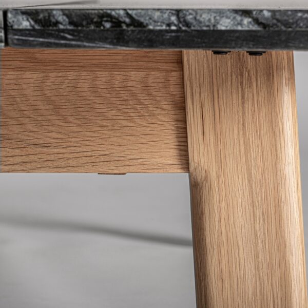 Primer plano de una pata de la mesa de centro en madera natural.