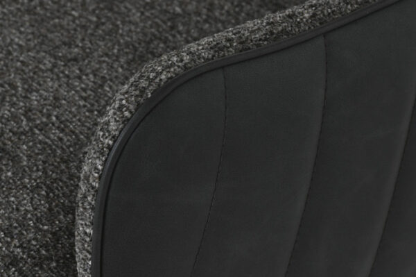 Detalle del reposabrazos tapizado en PU negro con costuras visibles.