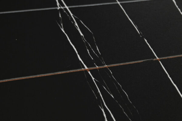 Primer plano de la textura del tablero cerámico negro con vetas blancas
