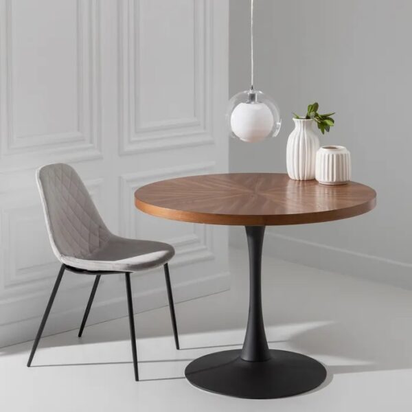 Mesa redonda de madera con base negra en un entorno decorado