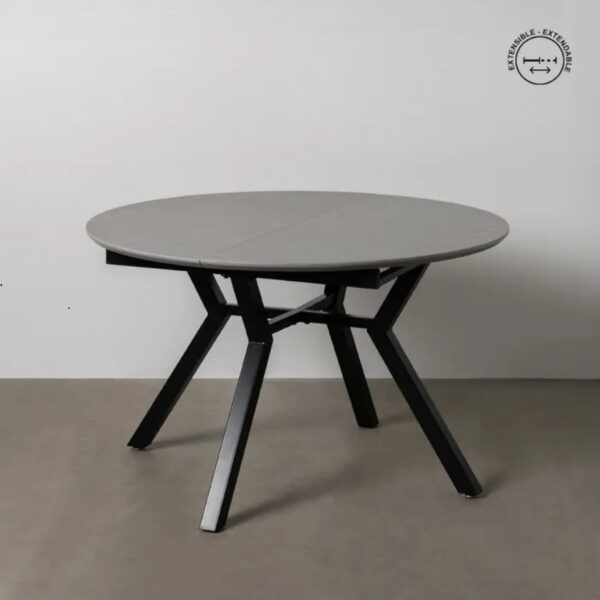 Mesa extensible redonda con patas de metal negro y tablero cerámico gris.