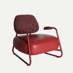 Sillón Tankah de la marca Kodu en color rojo con respaldo y reposabrazos tapizados, estructura metálica curva y asiento de polipiel.