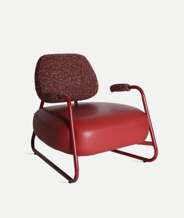 Sillón Tankah de la marca Kodu en color rojo con respaldo y reposabrazos tapizados, estructura metálica curva y asiento de polipiel.