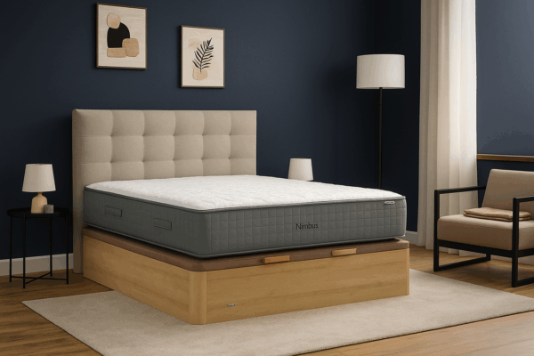 Colchón Flex Nimbus sobre base abatible de madera en habitación con pared azul marino y cabecero capitoné beige.