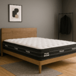 Colchón Flex Nube Multi sobre cama de madera clara en habitación gris minimalista con lámpara negra, cuadro abstracto y perchero con chaqueta