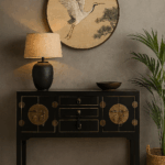 Consola negra oriental con herrajes de latón en un elegante salón, junto a lámpara y cuadro de grulla.