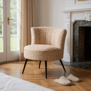 Sillón tapizado jaspeado en tonos beige con patas metálicas negras sobre fondo neutro