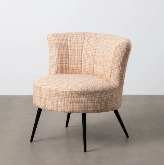 Sillón tapizado jaspeado en tonos beige con patas metálicas negras sobre fondo neutro