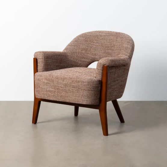Sillón tapizado beige-marrón con estructura de madera sobre suelo de parquet y fondo neutro