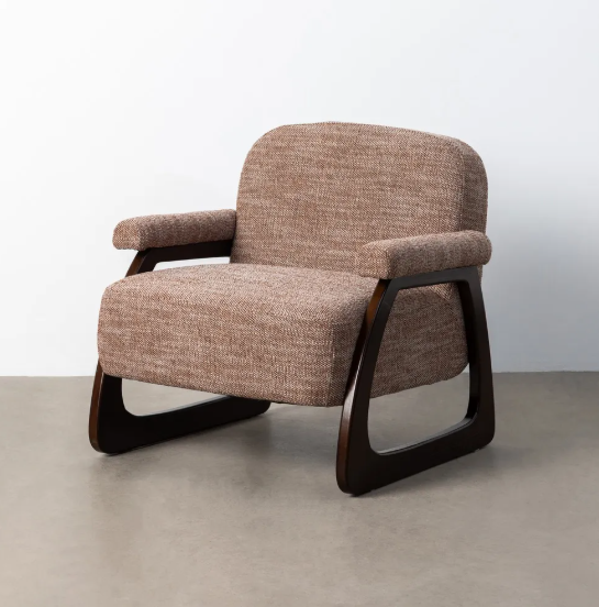 Sillón tapizado beige-marrón con estructura de madera oscura sobre suelo de parquet y fondo neutro
