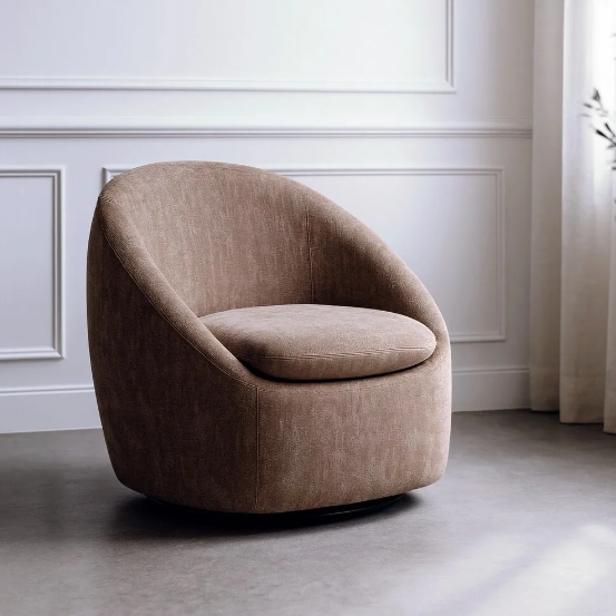 Sillón giratorio tapizado color taupe con base metálica sobre fondo blanco y suelo de cemento
