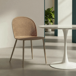 Silla color caqui de polipropileno con patas metálicas junto a mesa blanca redonda en ambiente moderno