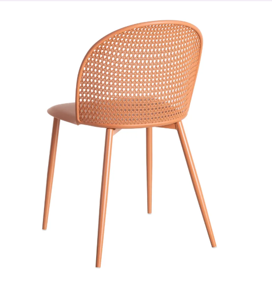 Silla color teja fabricada en polipropileno con respaldo calado y patas metálicas sobre fondo blanco