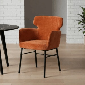 Silla color terracota tapizada en tejido con patas metálicas negras sobre suelo gris