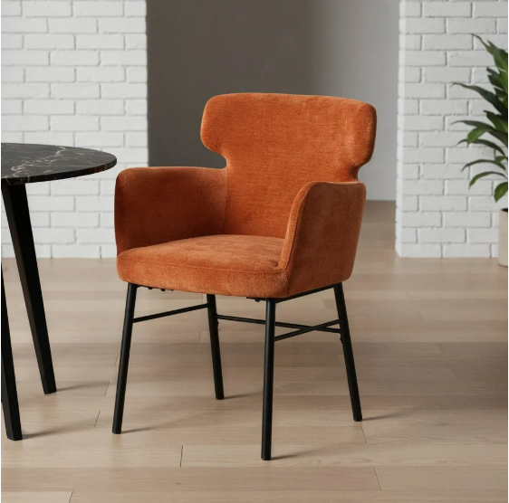 Silla color terracota tapizada en tejido con patas metálicas negras sobre suelo gris