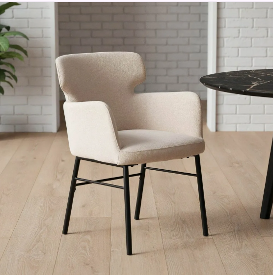Silla color crema tapizada en tejido con patas metálicas negras sobre suelo gris