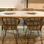 Mesa redonda extensible en madera de roble nordish con sillas de ratán en ambiente comedor