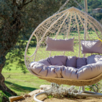 Sillón colgante doble de ratán sintético en terraza exterior