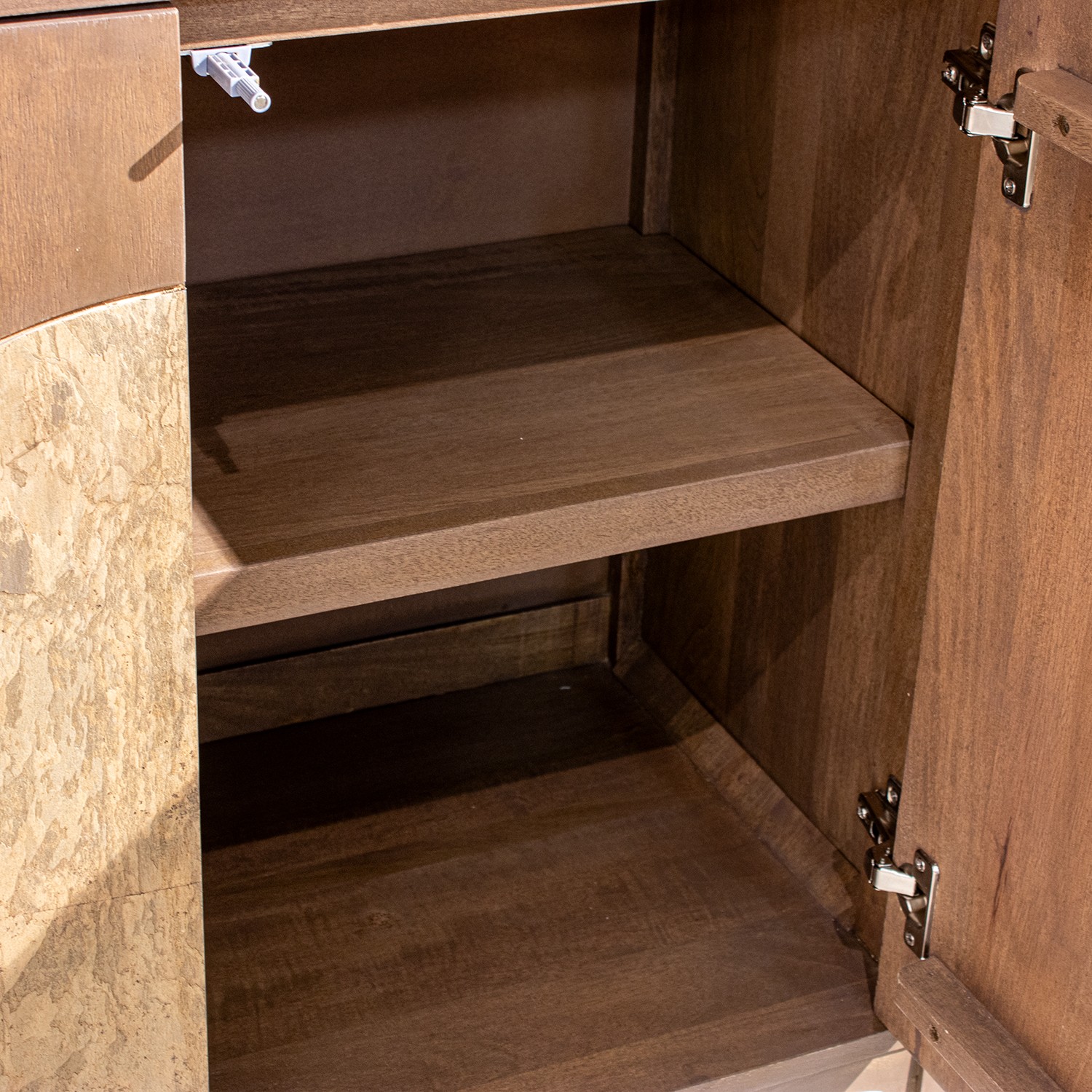 Aparador de la colección Artisa fabricado en madera de mango con puertas de piedra natural, patas altas y diseño contemporáneo. Disponible junto con mueble TV y estantería en dos acabados de armazón para crear un salón elegante y acogedor.